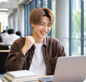 ノートパソコンに向かいガッツポーズする大学1年生のHさん