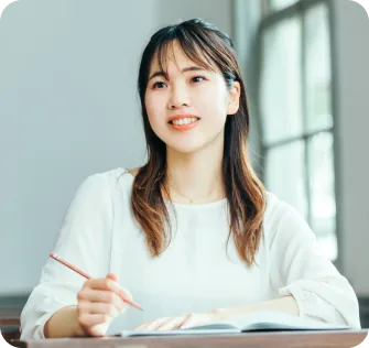 ノートを取りながら微笑む大学2年生のSさん